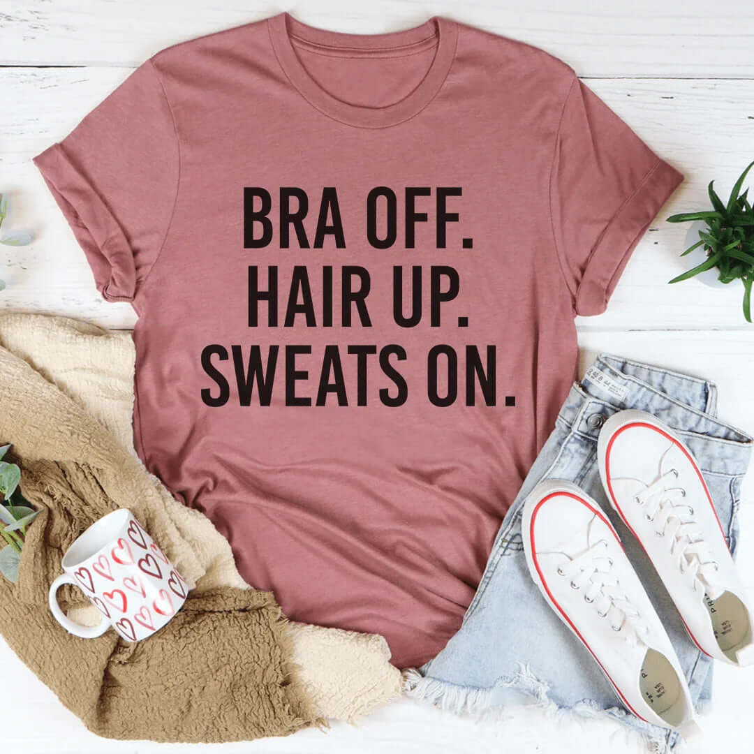 Womens clothing online t-shirt with printed phrase: 'BRA OFF. HAIR UP. SWEATS ON.' styled with casual accessories.