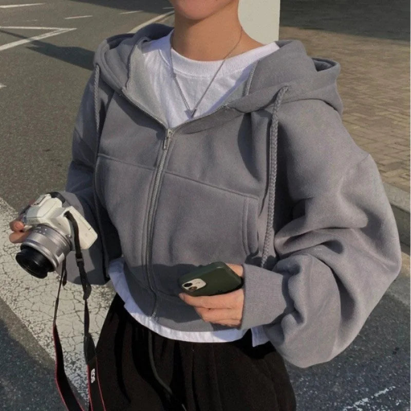 Cropped zip-up sweatshirt in gray worn casually, perfect for a stylish, relaxed look.