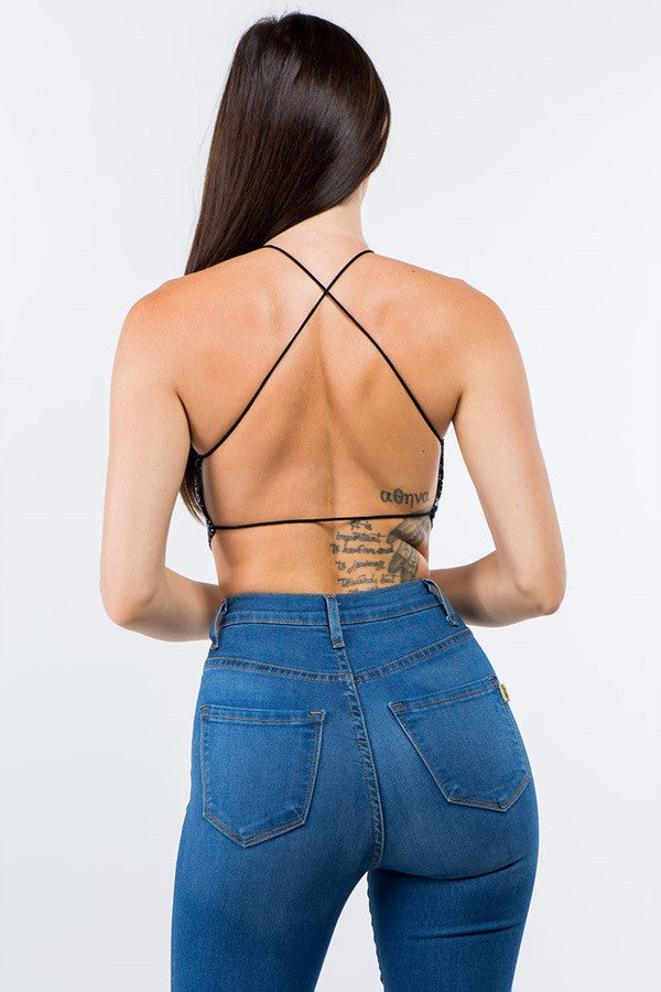 Back view of a woman wearing a sleeveless halter neck boho bandana crop top with crisscross open back detail.