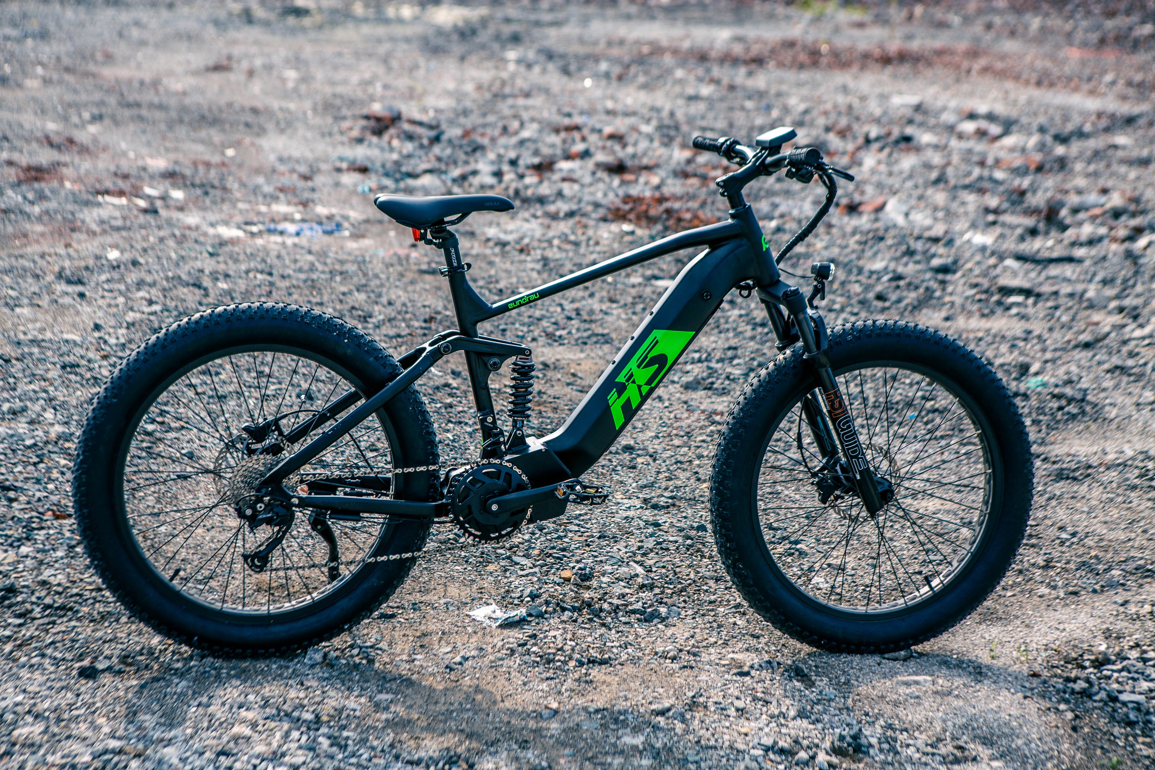FAT-HS Hunter X8 fat tire electric bike on rough terrain, showcasing its robust design and features.