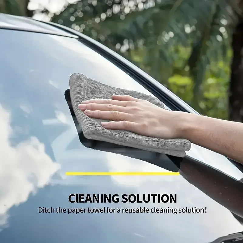 Person using microfiber cleaning cloths on a car window for effective cleaning solution.