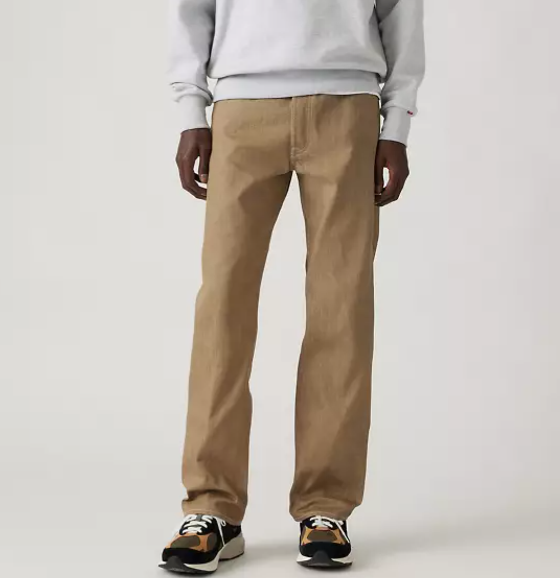 501 Original Shrink-to-fit men's jeans displayed on a model wearing a casual outfit with a sweatshirt and sneakers.