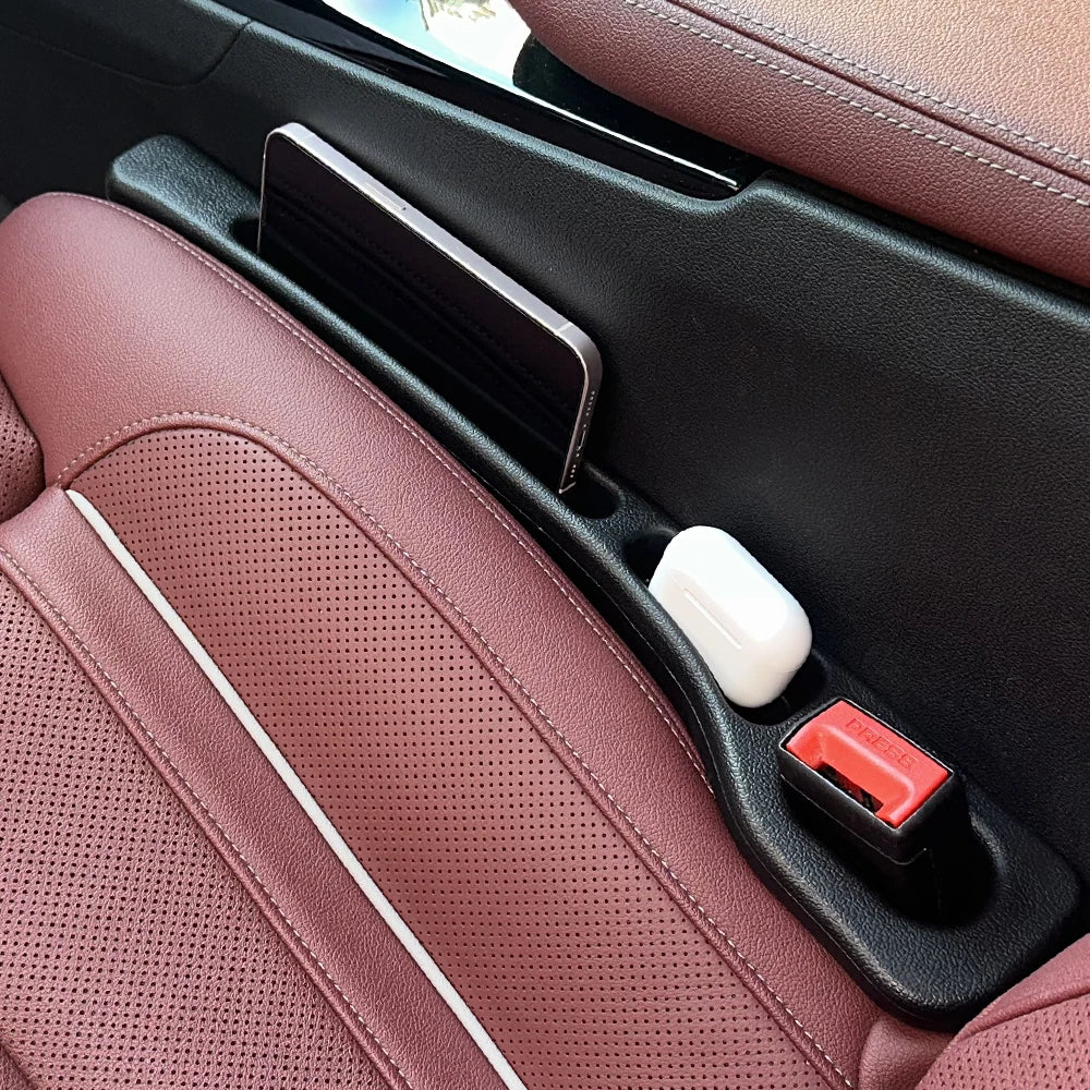 Car seat gap filler side with phone and essentials securely stored in car seat gap.