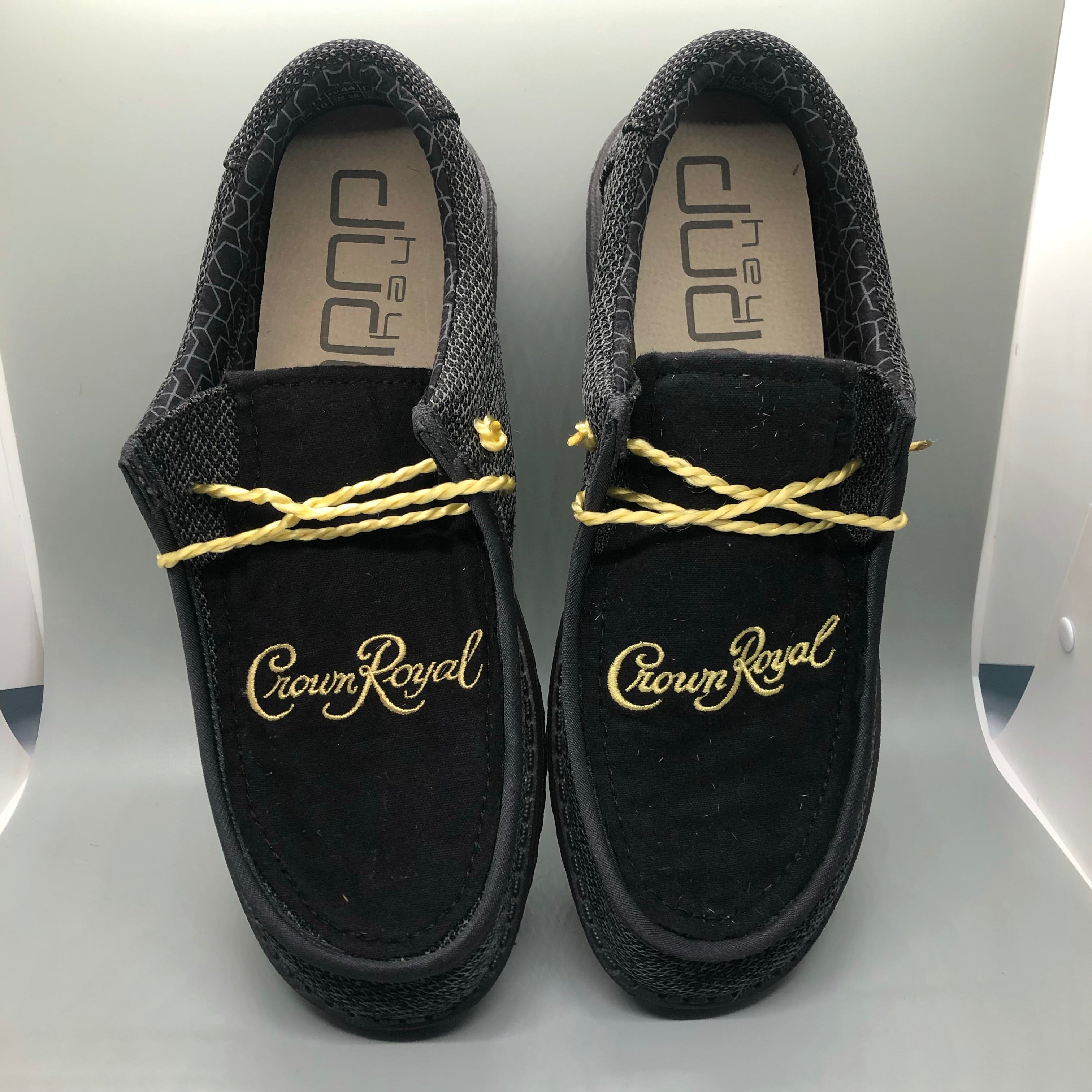 Black Crown Hey Dudes preorder shoes with yellow laces and Crown Royal branding.