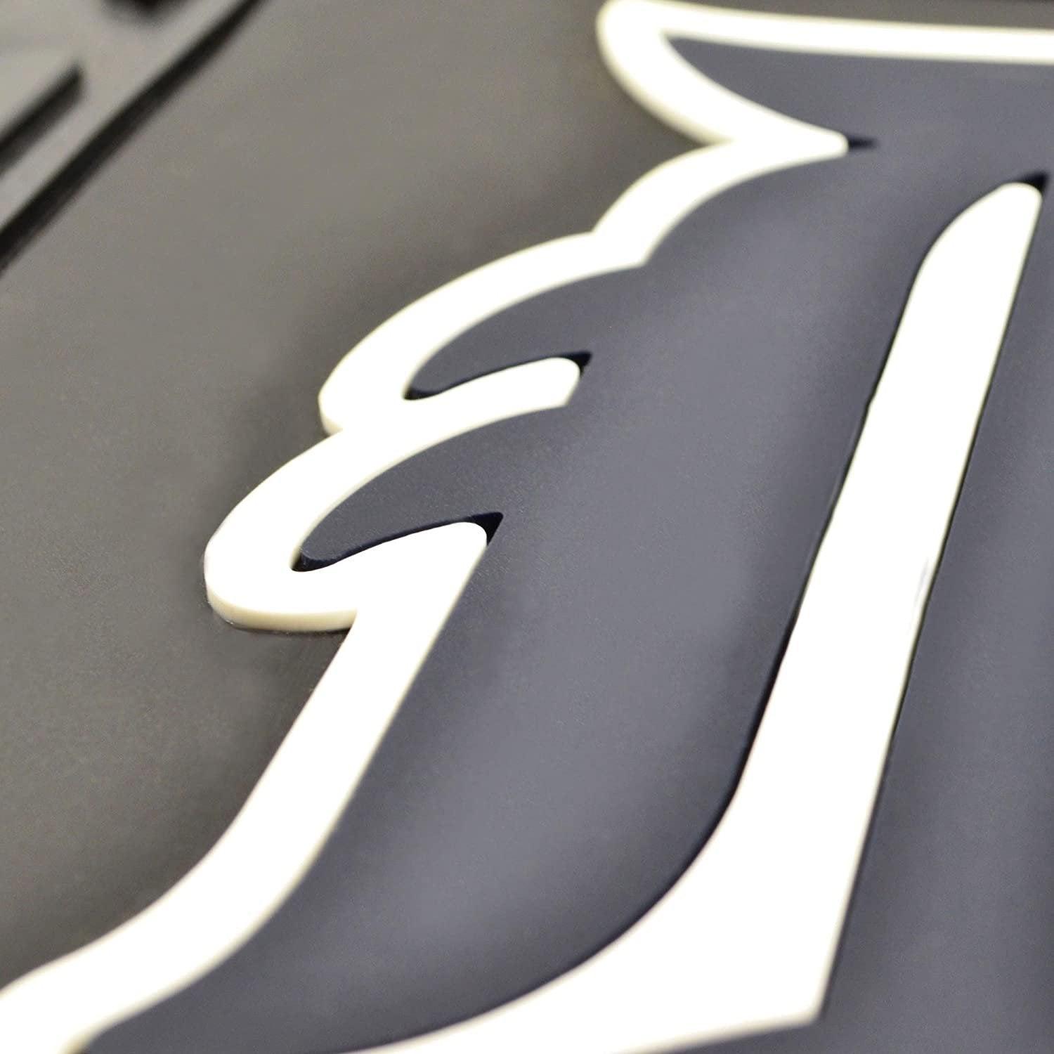 Close-up of molded 3D team logo on heavy duty vinyl car mats showcasing detailed design.